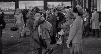 Movie still from “Ship of Fools” (1965), directed by Stanley Kramer – An old photo of a group of people gathered together; Wide shot, Over the shoulder angle