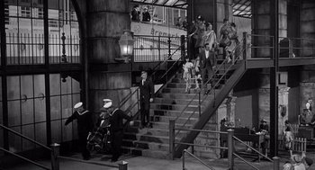 Movie still from “Ship of Fools” (1965), directed by Stanley Kramer – A black and white photo of people walking down stairs; Extreme Wide shot, High angle