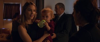 A woman holding a baby drinking from a bottle