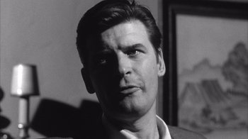 Movie still from “Shock Corridor” (1963), directed by Samuel Fuller – Black and white photograph of a man in a suit; Close Up shot, Low angle