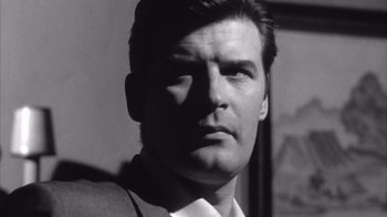 Movie still from “Shock Corridor” (1963), directed by Samuel Fuller – Black and white photograph of a man in a suit and tie; Close Up shot, Low angle