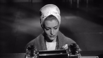 Movie still from “Shock Corridor” (1963), directed by Samuel Fuller – A black and white photo of a woman wearing a head scarf; Close Up shot, High angle