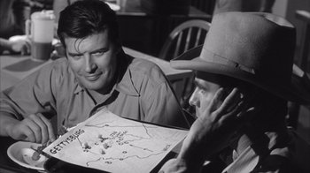 Movie still from “Shock Corridor” (1963), directed by Samuel Fuller – Two men sitting at a table looking at a board game; Close Up shot, Over the shoulder angle