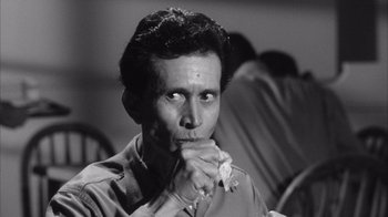 Movie still from “Shock Corridor” (1963), directed by Samuel Fuller – A black - and - white photo of a man holding a piece of paper; Close Up shot, Low angle