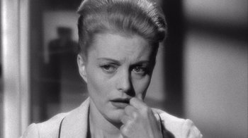 Movie still from “Shock Corridor” (1963), directed by Samuel Fuller – A black - and - white photo of a woman with her hand to her face; Close Up shot, High angle