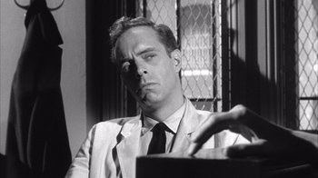 Movie still from “Shock Corridor” (1963), directed by Samuel Fuller – A black and white photo of a man smoking a cigarette; Close Up shot, Low angle