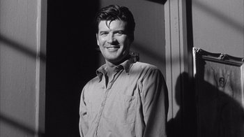 Movie still from “Shock Corridor” (1963), directed by Samuel Fuller – Black and white photograph of a man smiling for the camera; Close Up shot, Low angle