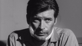 Movie still from “Shock Corridor” (1963), directed by Samuel Fuller – Black and white photograph of a man with a cigarette in his mouth; Close Up shot, Low angle