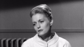 Movie still from “Shock Corridor” (1963), directed by Samuel Fuller – A black - and - white photo of a woman in a white jacket; Close Up shot, High angle