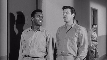 Movie still from “Shock Corridor” (1963), directed by Samuel Fuller – A black and white photo of two men standing next to each other; Medium shot, Low angle