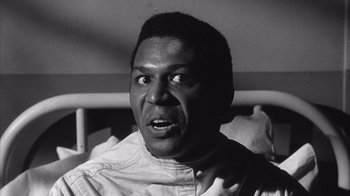 Movie still from “Shock Corridor” (1963), directed by Samuel Fuller – A black and white photo of a man looking surprised; Close Up shot, Low angle