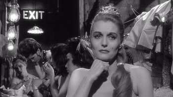 Movie still from “Shock Corridor” (1963), directed by Samuel Fuller – A black - and - white photo of a woman in a crowd of people; Close Up shot, Over the shoulder angle