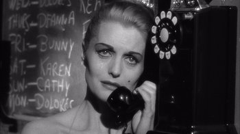 Movie still from “Shock Corridor” (1963), directed by Samuel Fuller – A black and white photo of a woman holding a phone to her ear; Close Up shot, High angle