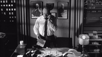 Movie still from “Shock Corridor” (1963), directed by Samuel Fuller – An old photo of a man talking on the phone; Medium shot, Low angle