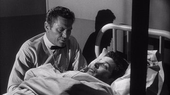 Movie still from “Shock Corridor” (1963), directed by Samuel Fuller – An old photo of a man in a hospital bed; Medium shot, Over the shoulder angle