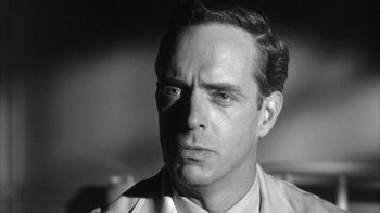 Movie still from “Shock Corridor” (1963), directed by Samuel Fuller – An old photo of a man with a serious look on his face; Close Up shot, Low angle