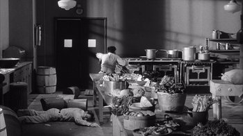 Movie still from “Shock Corridor” (1963), directed by Samuel Fuller – A black - and - white photo of people in a kitchen; Wide shot, High angle