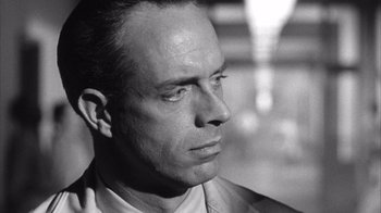 Movie still from “Shock Corridor” (1963), directed by Samuel Fuller – Black and white photograph of a man looking to his left; Close Up shot, Over the shoulder angle