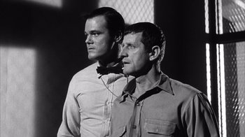 Movie still from “Shock Corridor” (1963), directed by Samuel Fuller – Two men standing next to each other in front of a window; Medium shot, Low angle