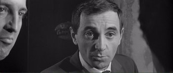 Movie still from “Shoot the Piano Player” (1960), directed by François Truffaut – Black and white photograph of a man in a suit and tie; Close Up shot, High angle