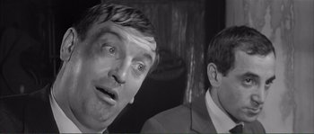 Movie still from “Shoot the Piano Player” (1960), directed by François Truffaut – Two men in suits and ties one of which is looking at the camera; Close Up shot, Low angle