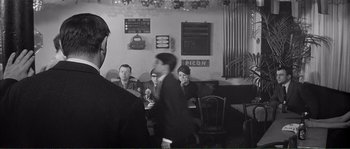 Movie still from “Shoot the Piano Player” (1960), directed by François Truffaut – A group of people sitting at a table in a restaurant; Medium shot, Over the shoulder angle