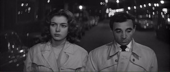 Movie still from “Shoot the Piano Player” (1960), directed by François Truffaut – A man and a woman standing next to each other on the street; Close Up shot, High angle