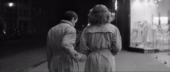 Movie still from “Shoot the Piano Player” (1960), directed by François Truffaut – A man and a woman holding hands while standing next to each other; Medium shot, Over the shoulder angle