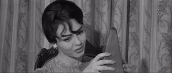 Movie still from “Shoot the Piano Player” (1960), directed by François Truffaut – A black and white photo of a woman looking at a mirror; Close Up shot, Low angle