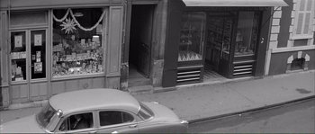 Movie still from “Shoot the Piano Player” (1960), directed by François Truffaut – An old car parked on the side of the street; Extreme Wide shot, High angle