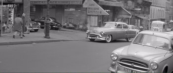 Movie still from “Shoot the Piano Player” (1960), directed by François Truffaut – An old photo of a car driving down the street; Extreme Wide shot, High angle