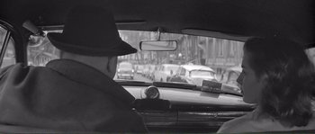 Movie still from “Shoot the Piano Player” (1960), directed by François Truffaut – A black and white photo of a man driving a car; Medium shot, High angle