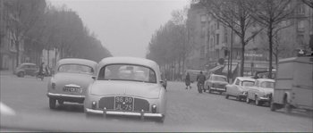 Movie still from “Shoot the Piano Player” (1960), directed by François Truffaut – An old photo of cars driving down the street; Wide shot, High angle