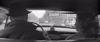 Movie still from “Shoot the Piano Player” (1960), directed by François Truffaut – A man driving a car on a busy city street; Medium shot, Low angle