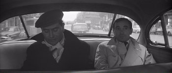 Movie still from “Shoot the Piano Player” (1960), directed by François Truffaut – Two men sitting in the back seat of a car; Medium shot, High angle
