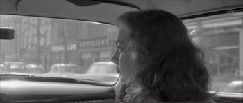 Movie still from “Shoot the Piano Player” (1960), directed by François Truffaut – A woman sitting in the passenger seat of a car looking out the window; Close Up shot, Over the shoulder angle