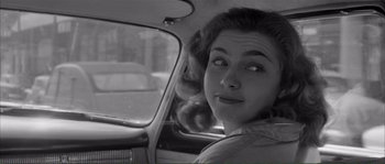 Movie still from “Shoot the Piano Player” (1960), directed by François Truffaut – A black and white photo of a woman in the backseat of a car; Close Up shot, Over the shoulder angle