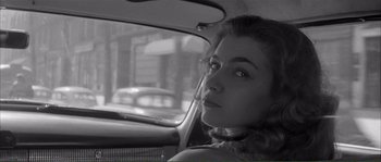 Movie still from “Shoot the Piano Player” (1960), directed by François Truffaut – A black and white photo of a woman in the backseat of a car; Close Up shot, High angle