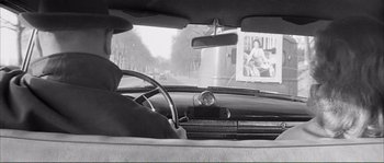 Movie still from “Shoot the Piano Player” (1960), directed by François Truffaut – A black and white photo of a car dashboard; Medium shot, Over the shoulder angle