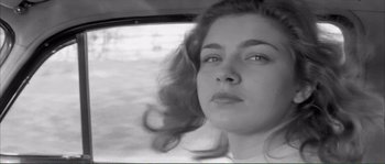Movie still from “Shoot the Piano Player” (1960), directed by François Truffaut – A black - and - white photo of a woman looking out a window; Close Up shot, Low angle