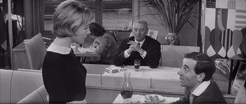 Movie still from “Shoot the Piano Player” (1960), directed by François Truffaut – An older man sitting at a table in a restaurant; Medium shot, Over the shoulder angle