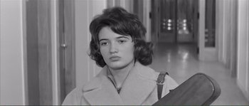 Movie still from “Shoot the Piano Player” (1960), directed by François Truffaut – A young woman with a purse in a hallway; Close Up shot, High angle