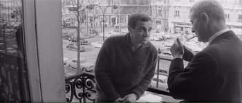 Movie still from “Shoot the Piano Player” (1960), directed by François Truffaut – A black and white photo of a man on a balcony; Medium shot, High angle