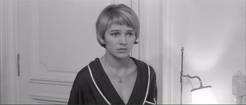 Movie still from “Shoot the Piano Player” (1960), directed by François Truffaut – A woman with short blonde hair wearing a black and white shirt; Close Up shot, High angle