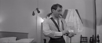 Movie still from “Shoot the Piano Player” (1960), directed by François Truffaut – A black and white photo of a man smoking a cigarette; Medium shot, Low angle