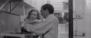 Movie still from “Shoot the Piano Player” (1960), directed by François Truffaut – A man and a woman in a kitchen; Medium shot, Over the shoulder angle