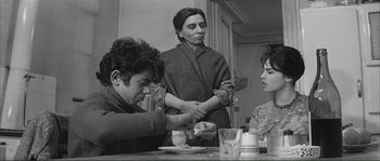 Movie still from “Shoot the Piano Player” (1960), directed by François Truffaut – Two women and a man sitting at a dinner table; Medium shot, High angle