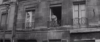 Movie still from “Shoot the Piano Player” (1960), directed by François Truffaut – A man standing on the balcony of an old building; Wide shot, Low angle