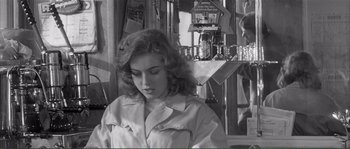Movie still from “Shoot the Piano Player” (1960), directed by François Truffaut – Black and white photograph of a young woman in front of a mirror; Medium shot, Over the shoulder angle