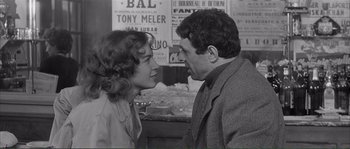 Movie still from “Shoot the Piano Player” (1960), directed by François Truffaut – A man and a woman face to face in front of signs; Medium shot, Over the shoulder angle